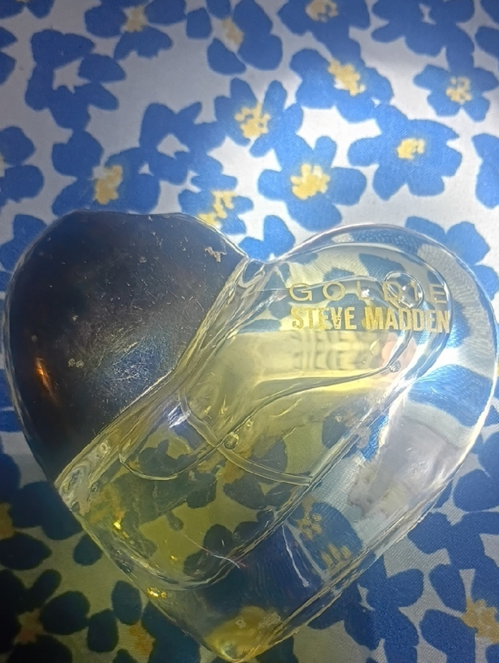 Steve Madden Heart-Shaped Clear Perfume Bottle with Gold Logo and Yellow Liquid